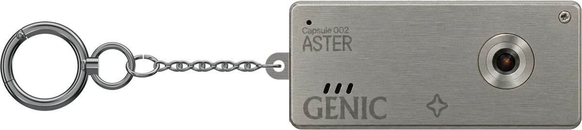 Capsule Nº002 ASTER, brushed-metal keychain camera on its chain